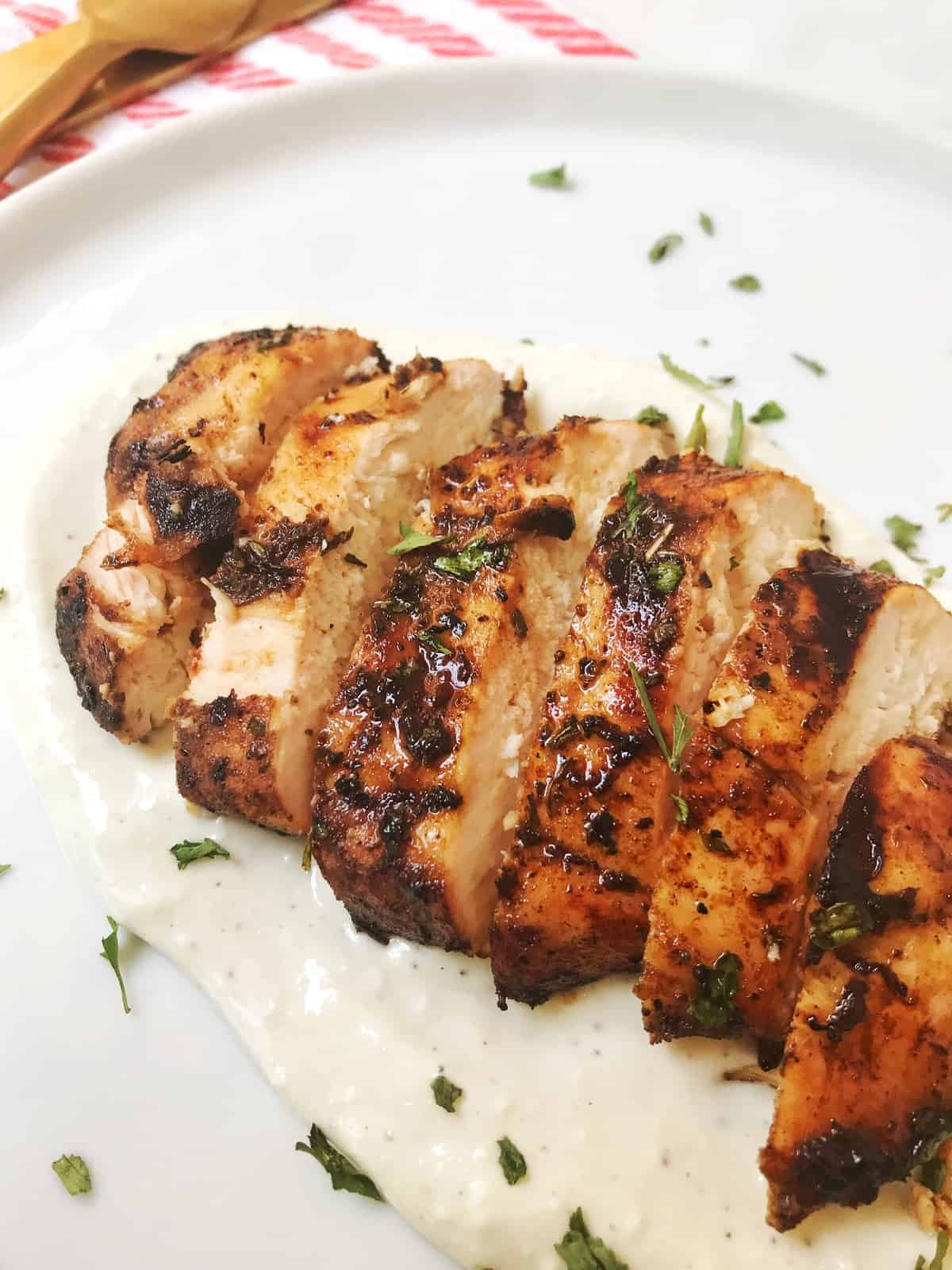 close up of sliced chicken on a bed of sauce