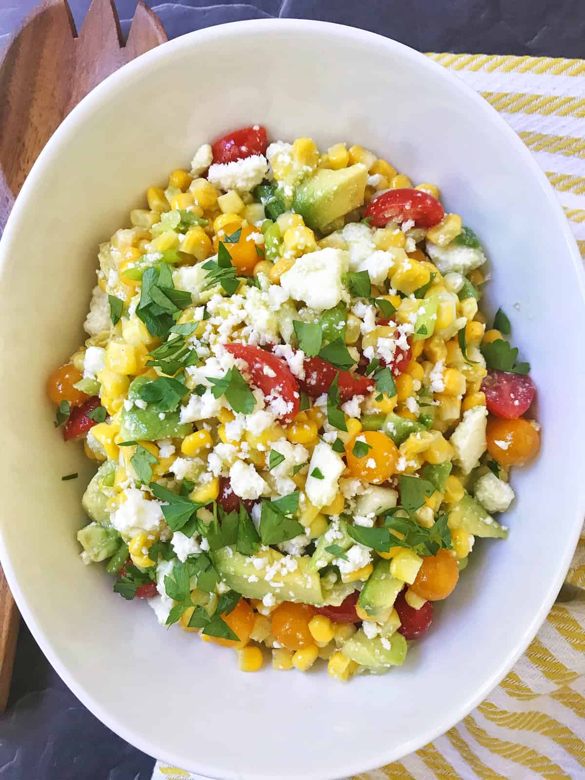 salad in a serving bowl with a wooden serving spoon