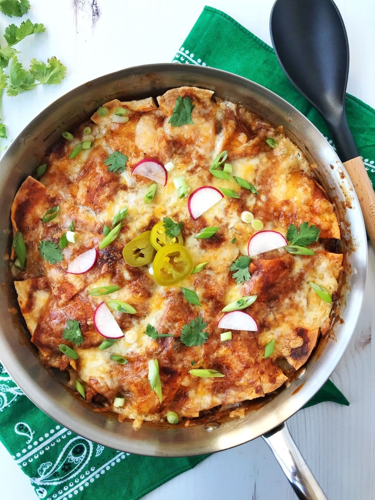 skillet of enchiladas with serving spoon