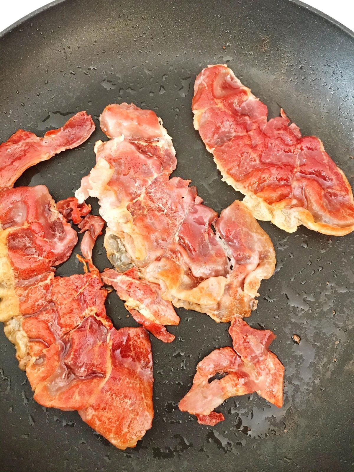 prosciutto frying in a pan