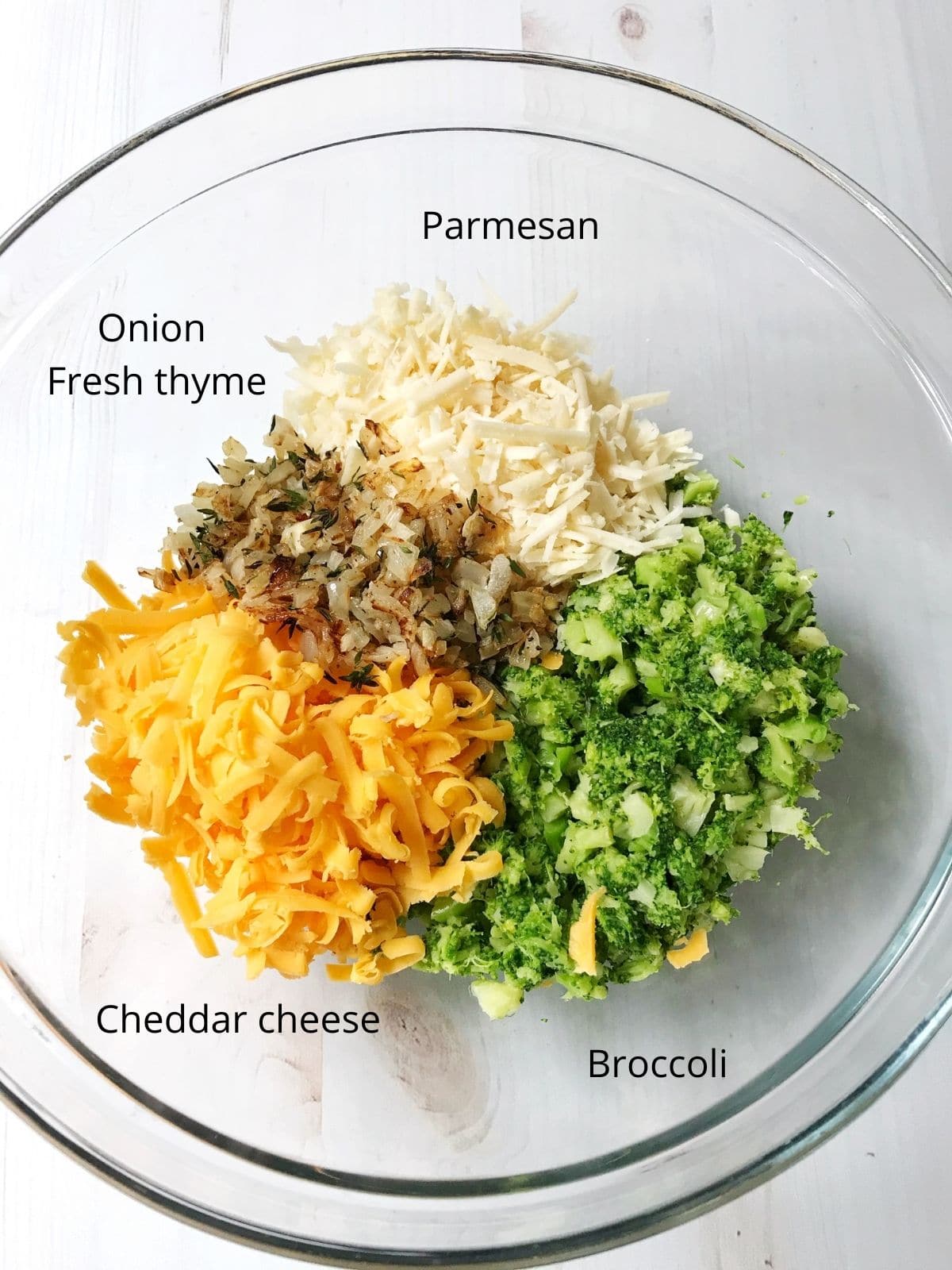 bowl of broccoli tart ingredients - broccoli, cheddar, onions, thyme, parmesan