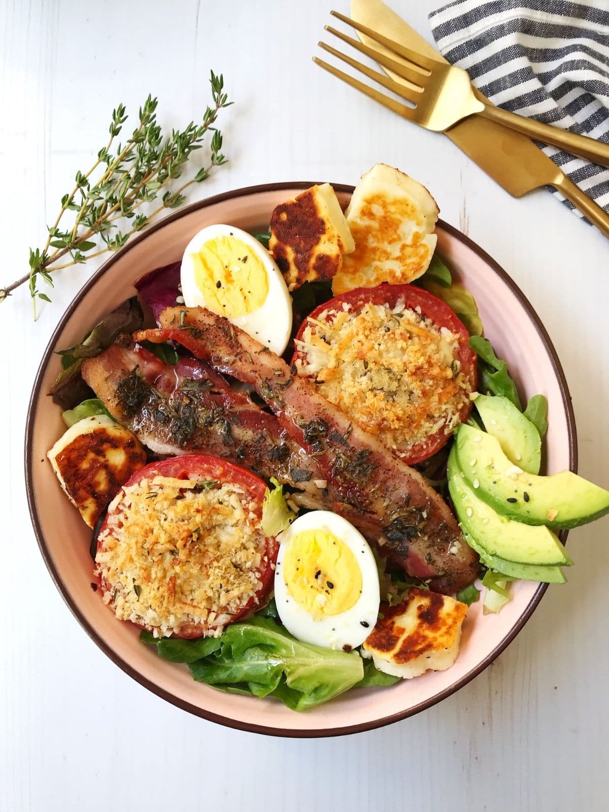 greens, roasted tomatoes, hard-boiled eggs, halloumi, and bacon