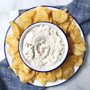 bowl of onion dip on a plate with chips