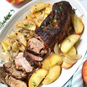 platter of pork surrounded by apples and onions