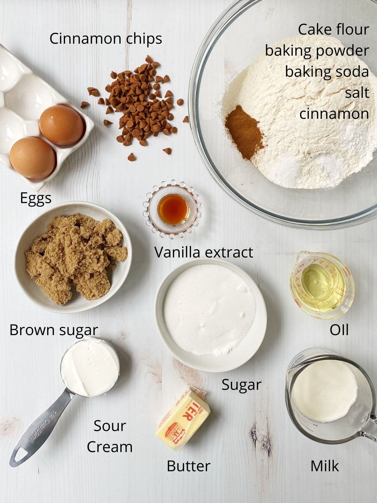 array of eggs, flour, sugars, milk, oil, sour cream, cinnamon chips, baking powder, baking soda, salt, ground cinnamon, butter