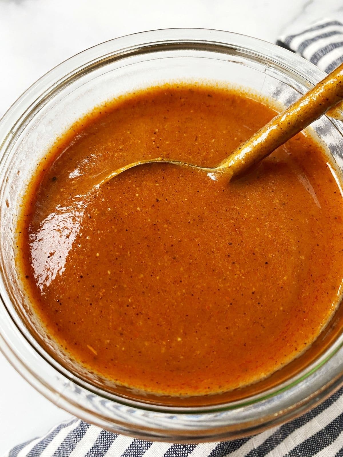 spoon in a jar of enchilada sauce
