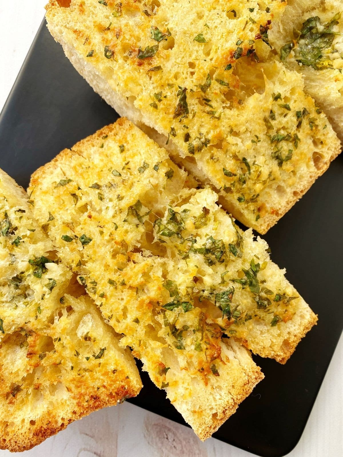 slices of garlic bread on a serving board.