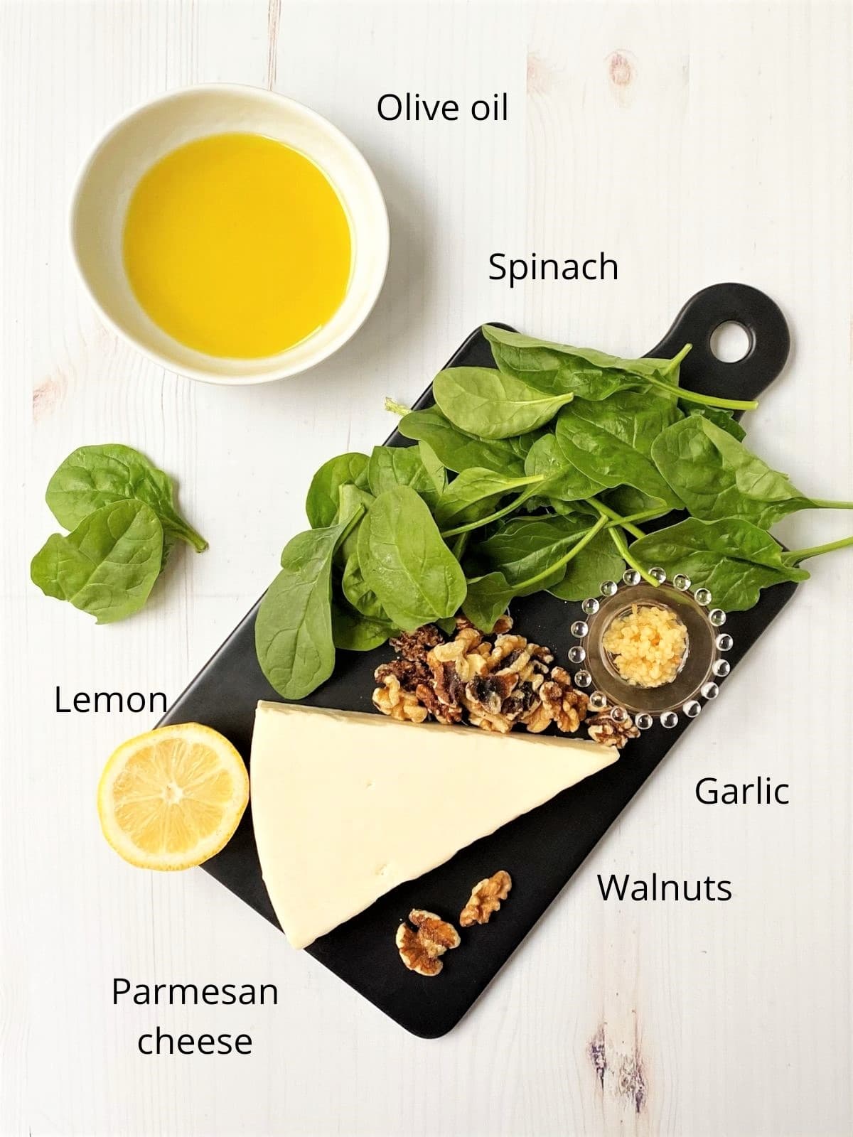 board with spinach, parmesan, garlic, walnuts, lemon, and oil for pesto