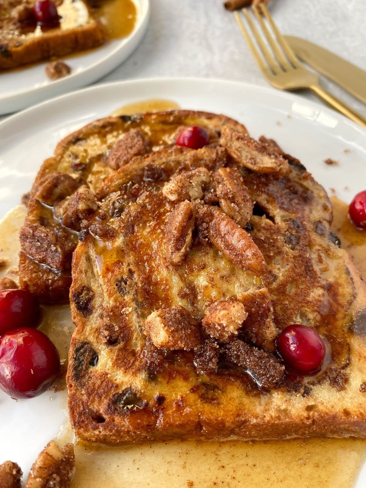 close up of french toast with syrup and candied pecans