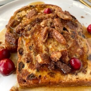 sliced of french toast on plate with pecans and syrup