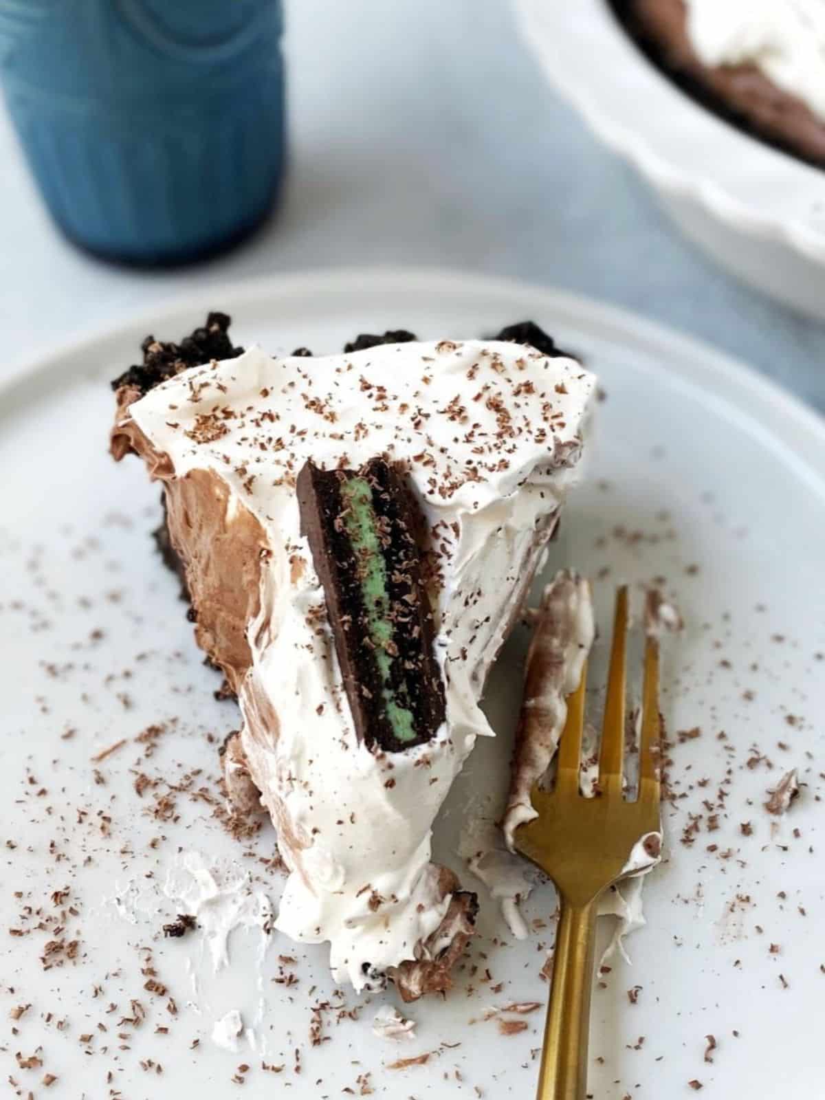 Slice of pie on a plate next to a glass of milk.