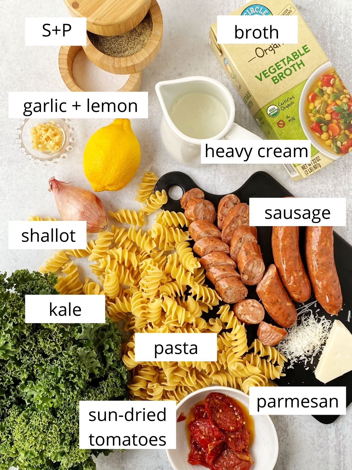 board with kale, sausage, pasta, cheese, shallots, and seasonings
