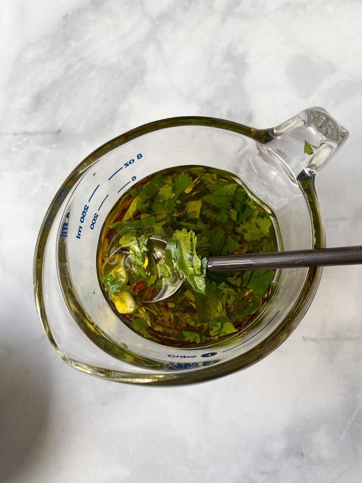 glass cup of olive oil mixed with seasonings