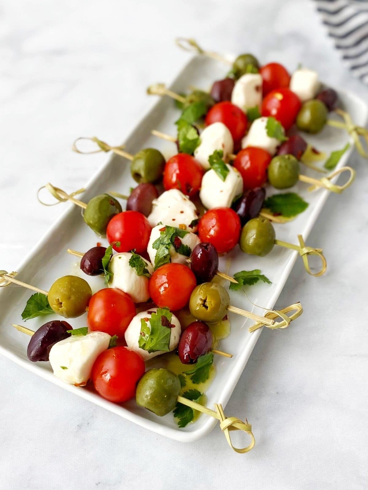 platter of mozzarella, tomato, and olive skewers