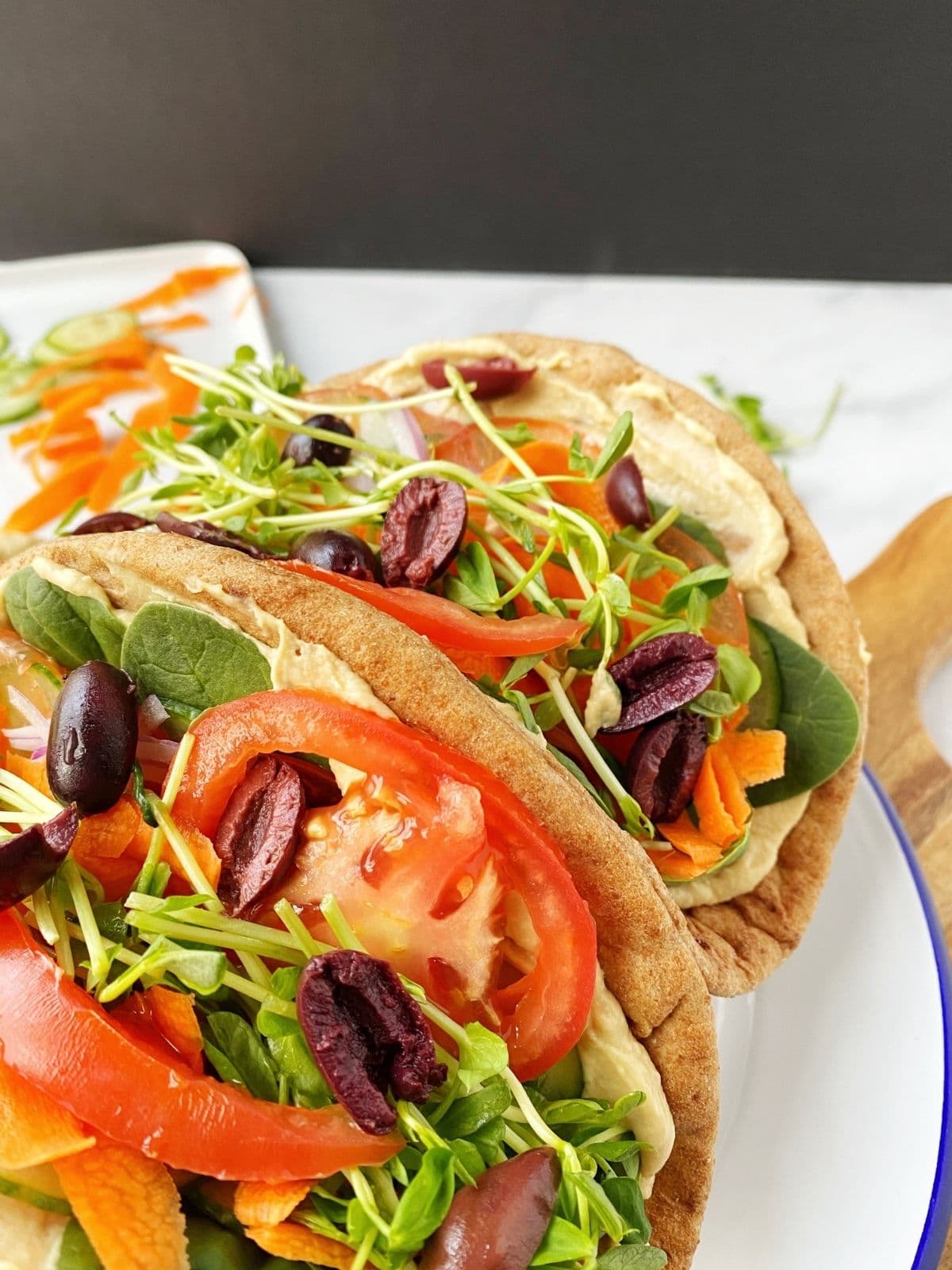 close up of veggies and hummus stuffed pita bread