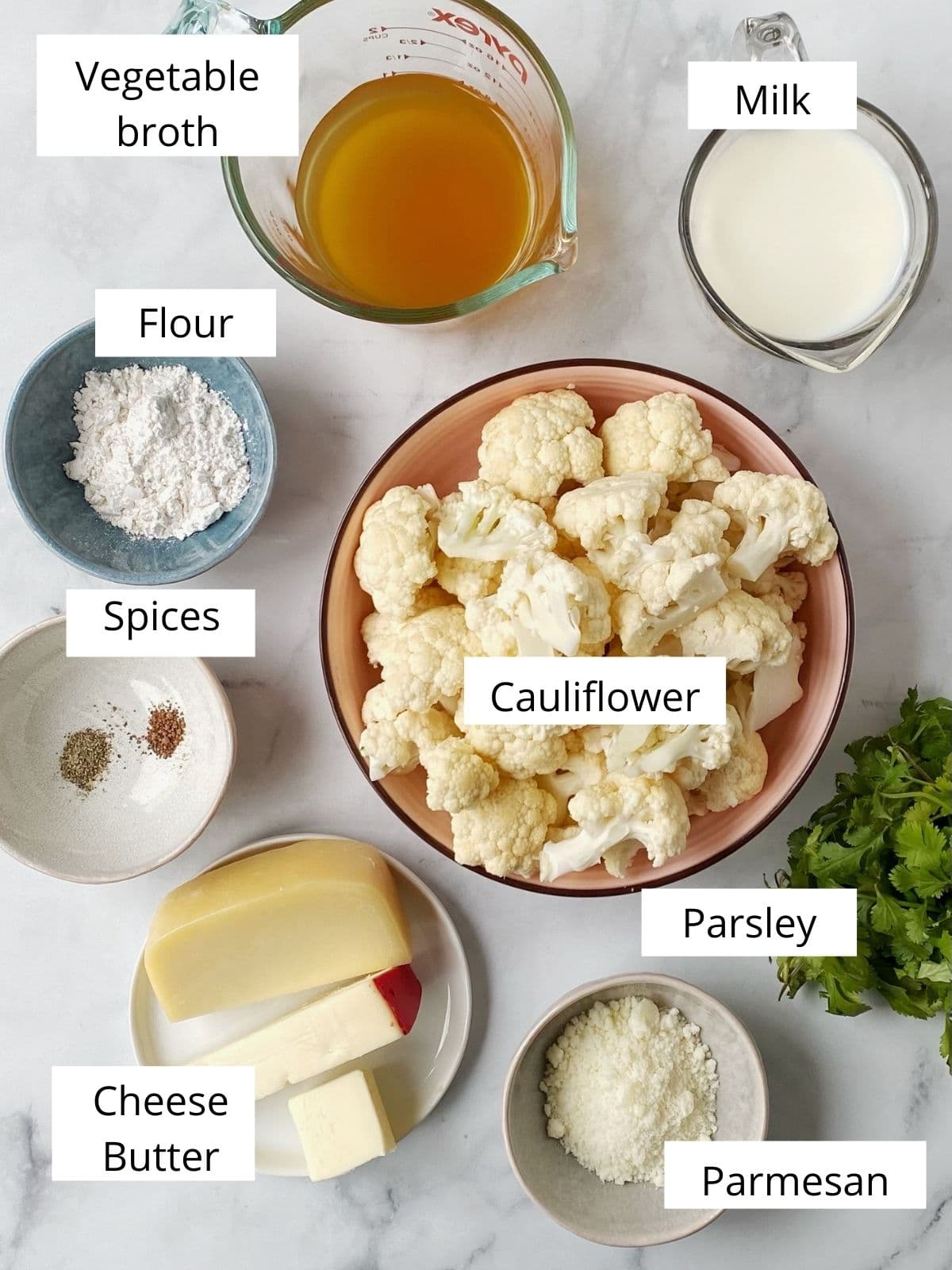 dishes of ingredients - cauliflower, milk, broth, cheese, spices, butter, flour