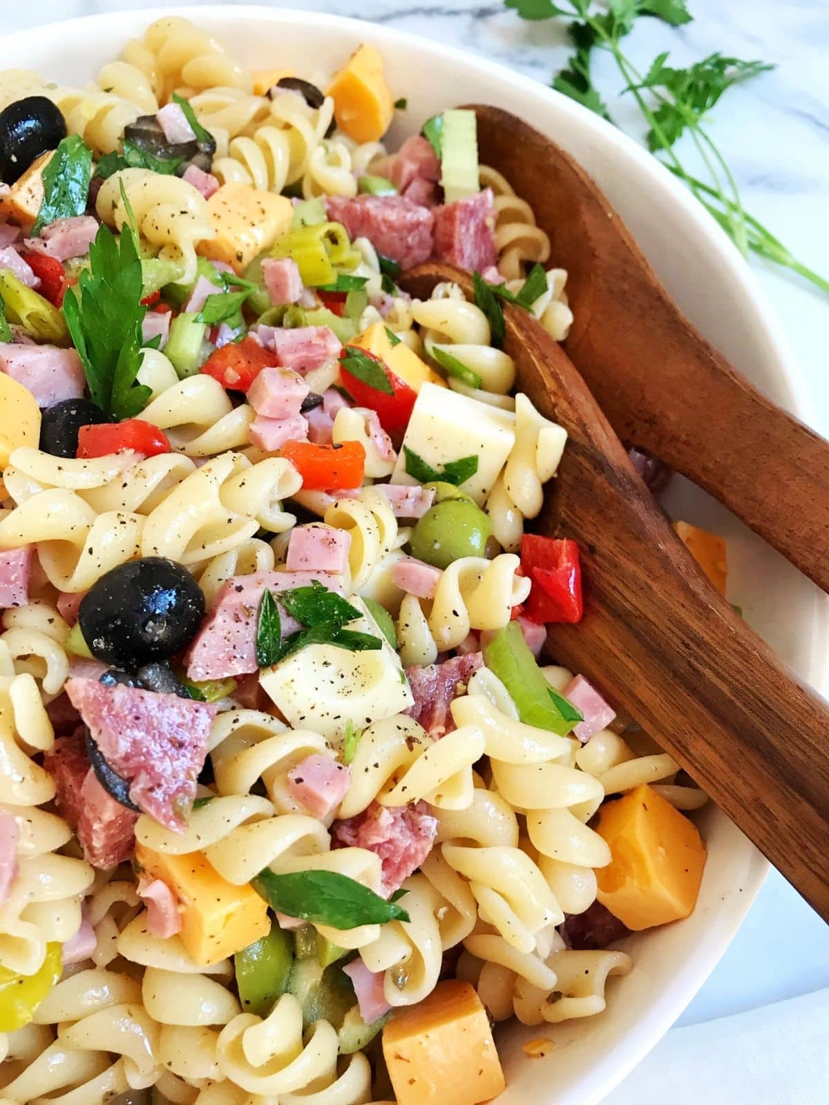 serving spoons in bowl of pasta salad