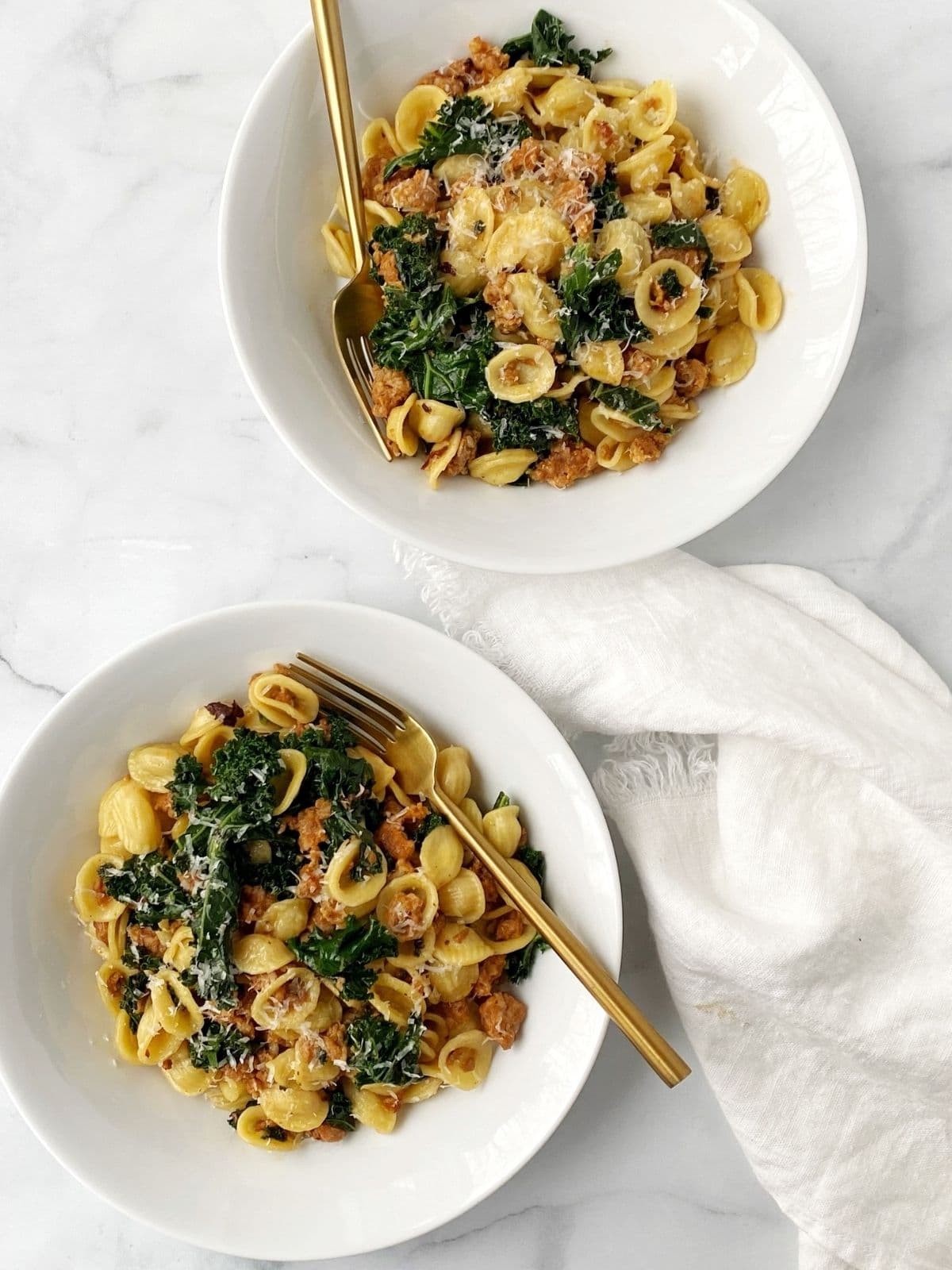 two bowls of pasta with forks