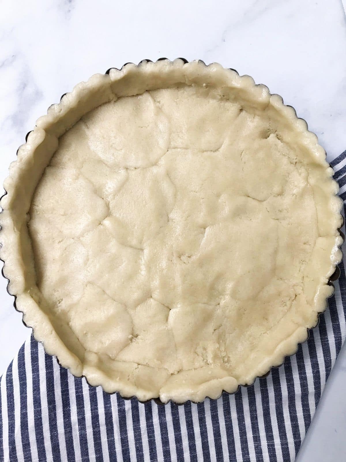 tart pan with dough formed into crust