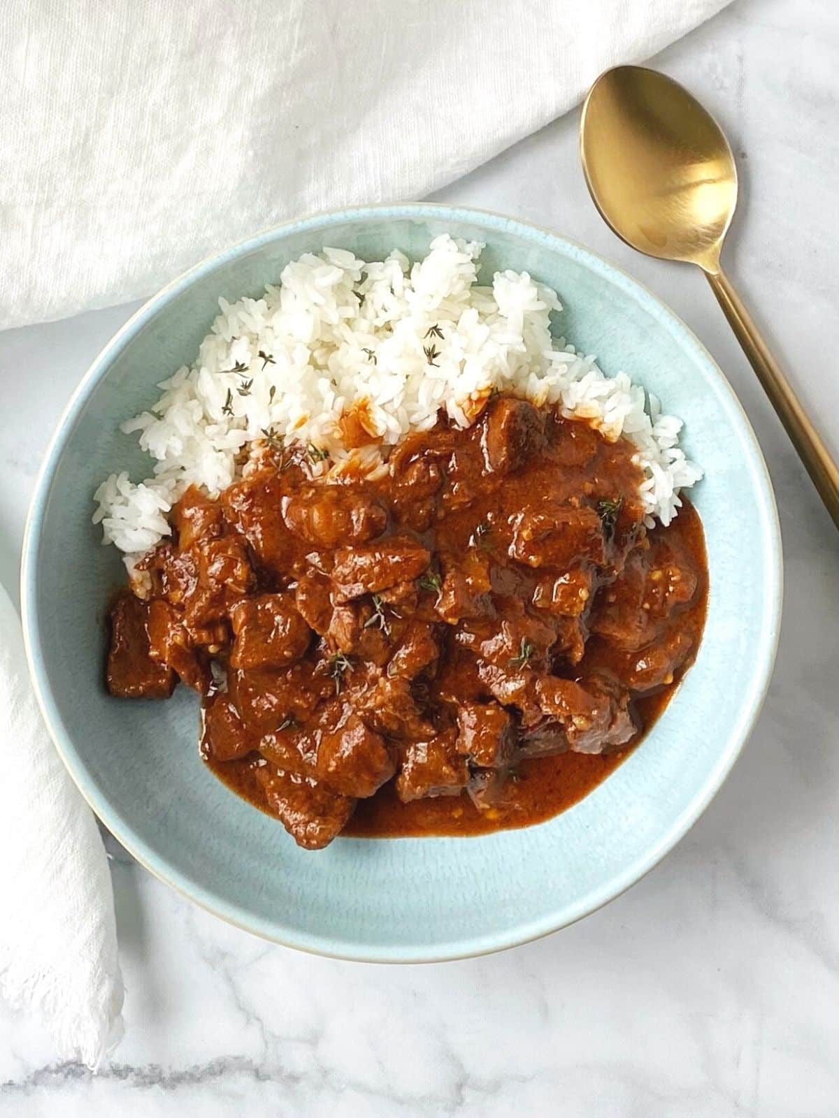 light blue bowl with rice and beef stew