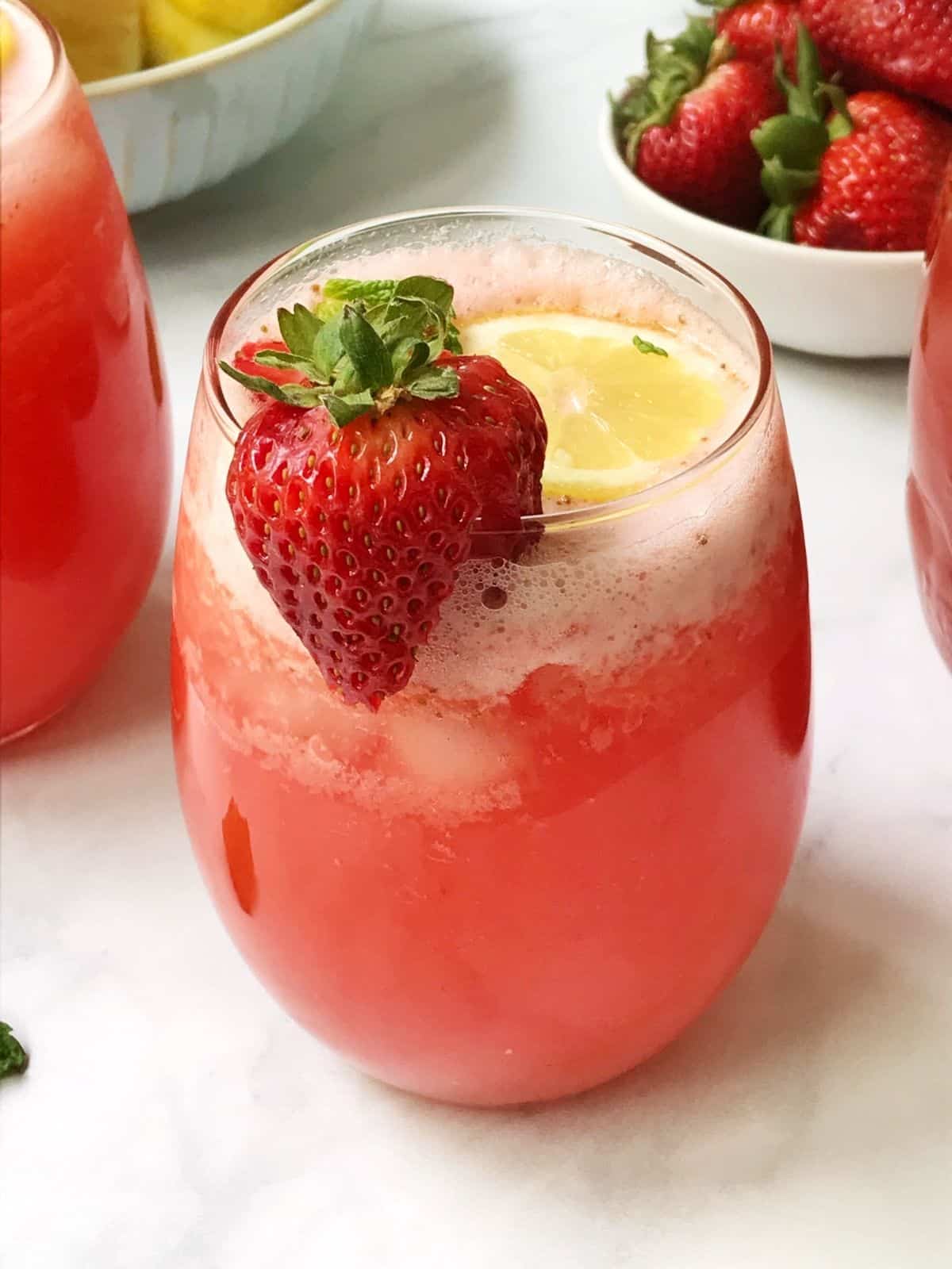 glass of lemonade with strawberry garnish