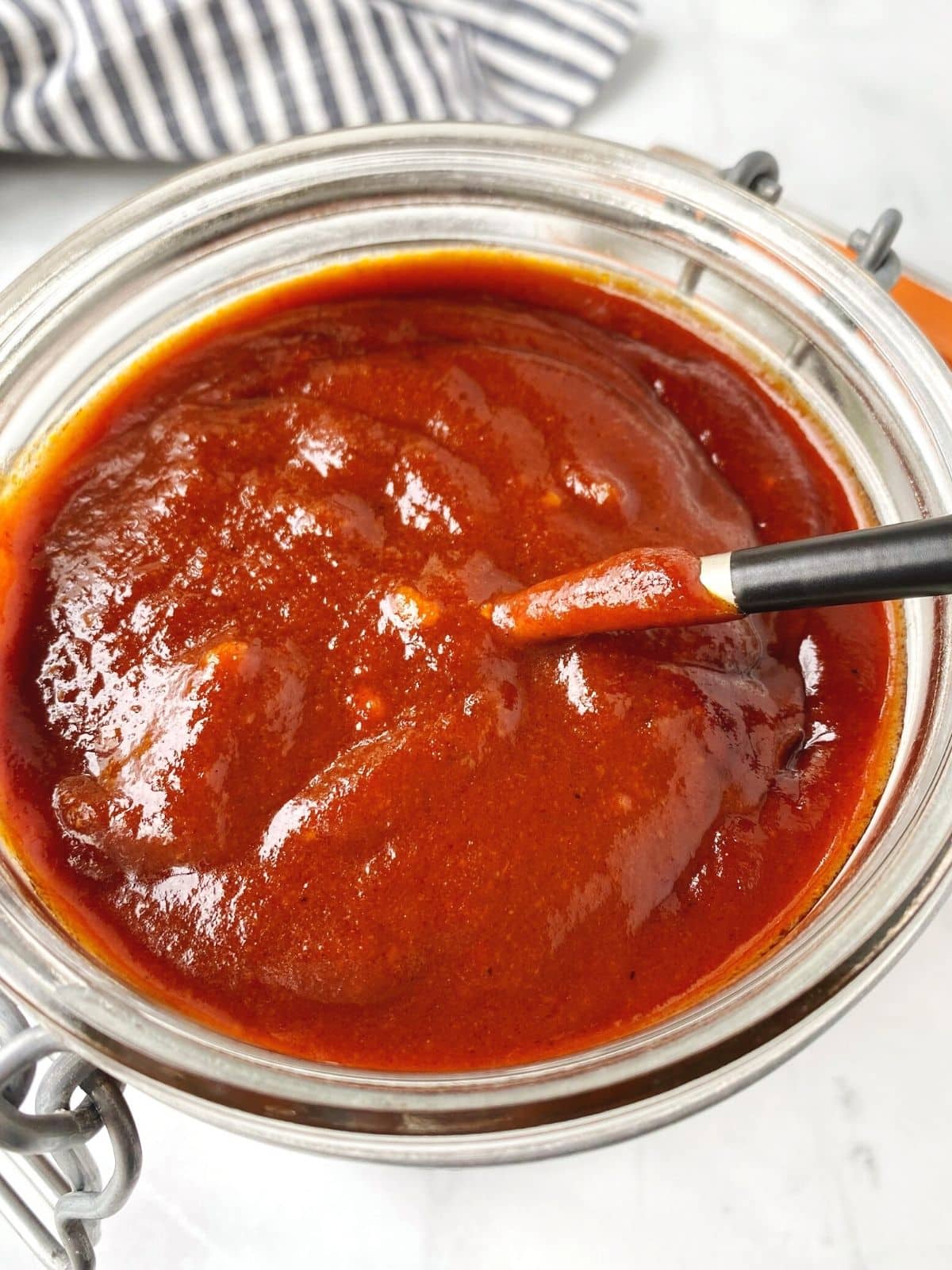close up of jar of sauce with spoon