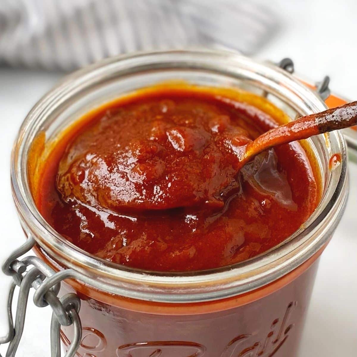 spoon in a jar of barbecue sauce