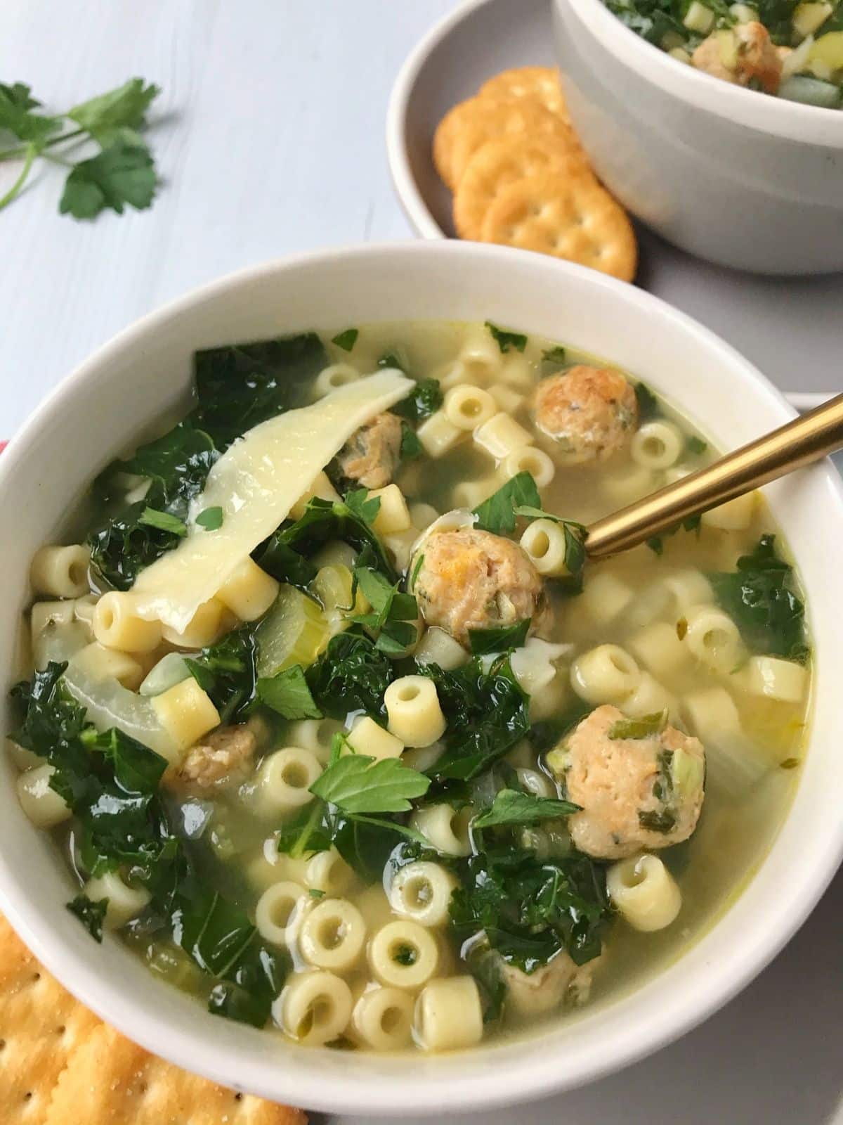 bowls of soup garnished with parmesan shavings and crackers