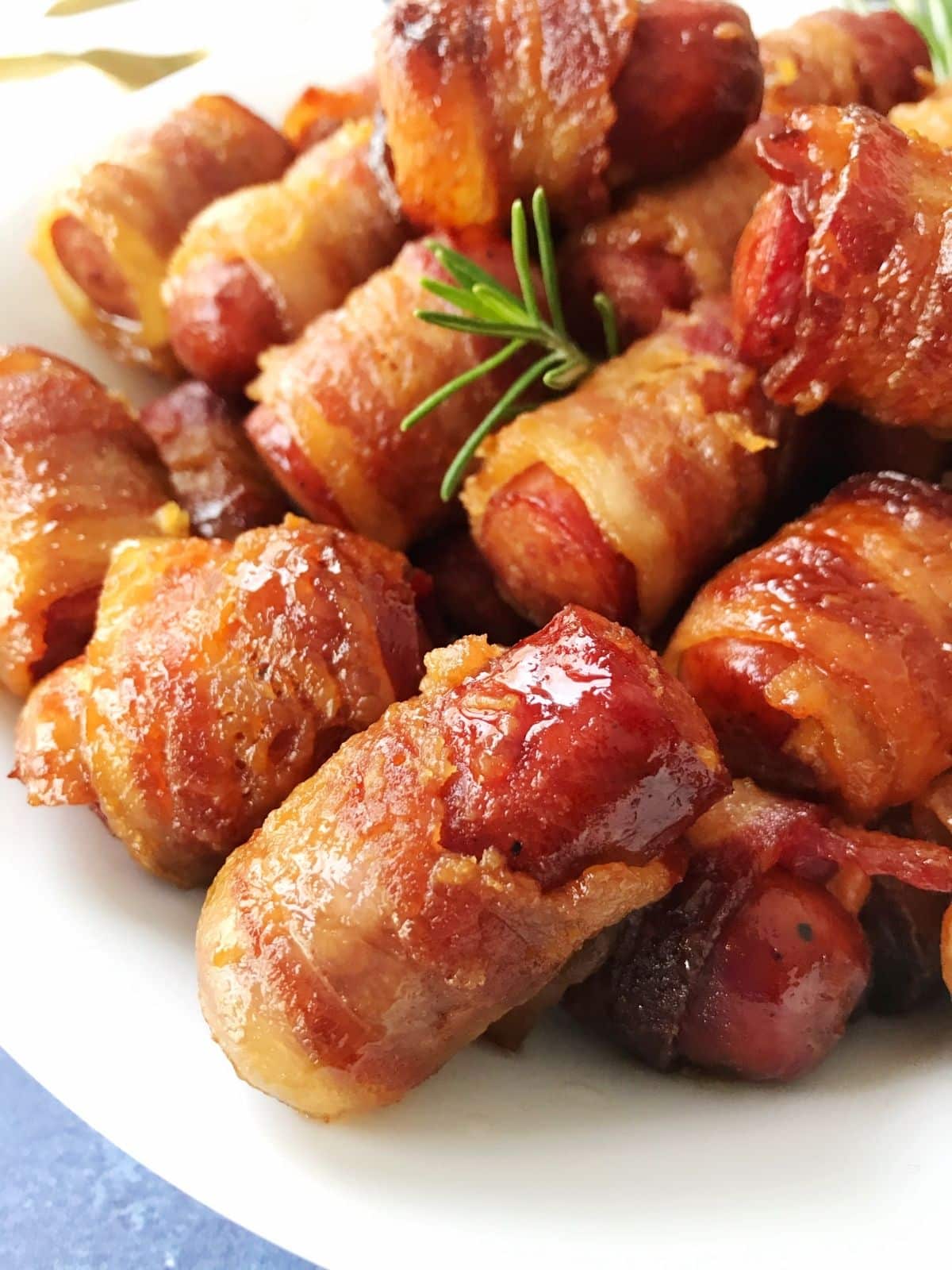 close up of bacon-wrapped sausages on a plate