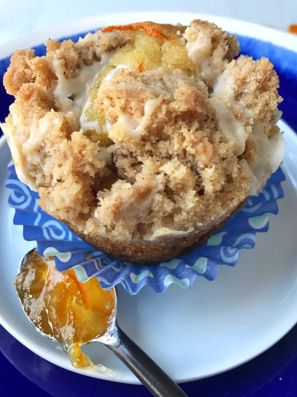 close up of muffin on a plate with a spoonful of marmalade