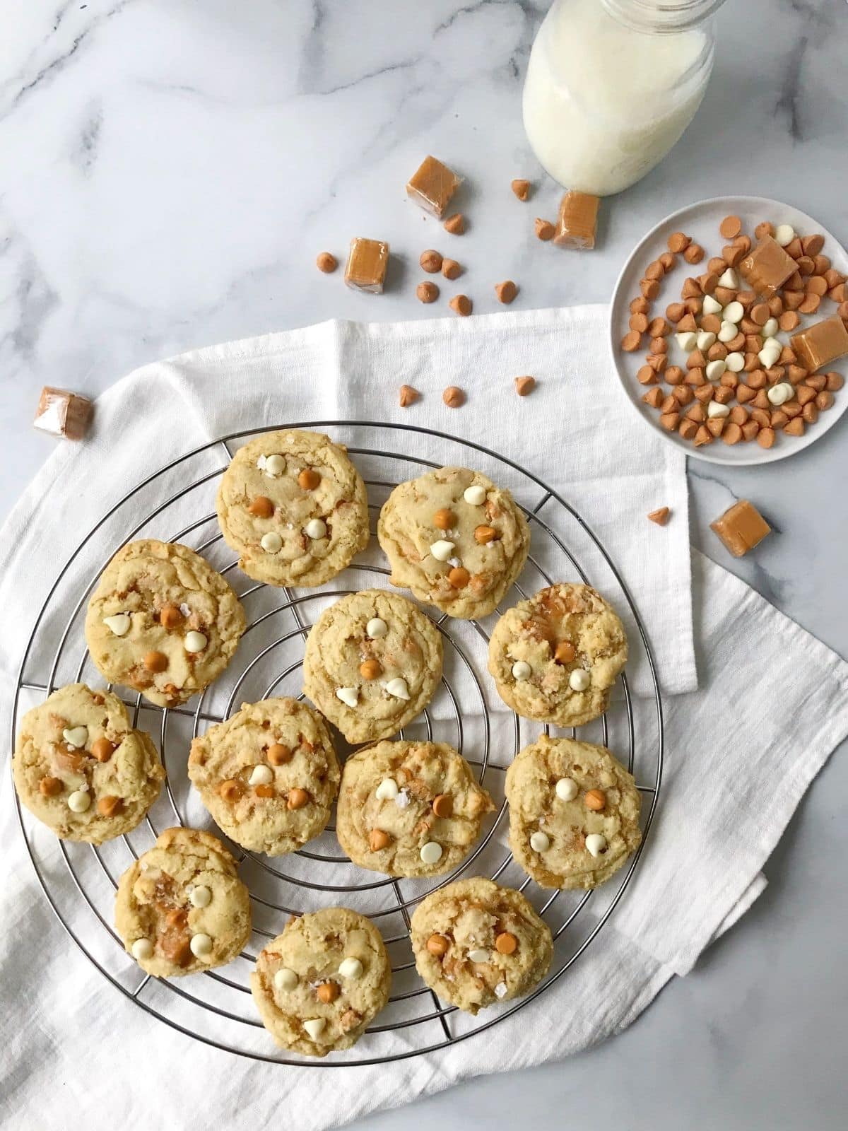 cookies on a cooking rack next to a glass of milk