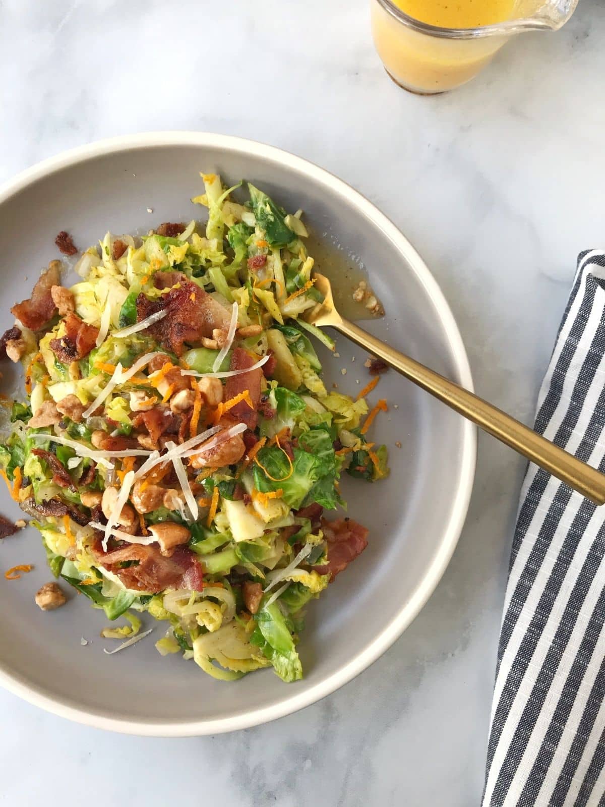 plate of warm salad with dressing on the side