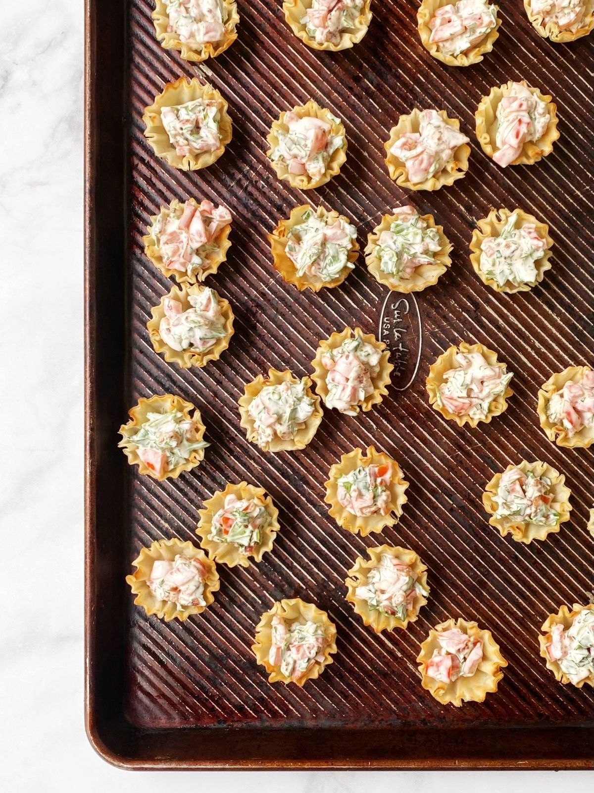 filled cups on a sheet pan