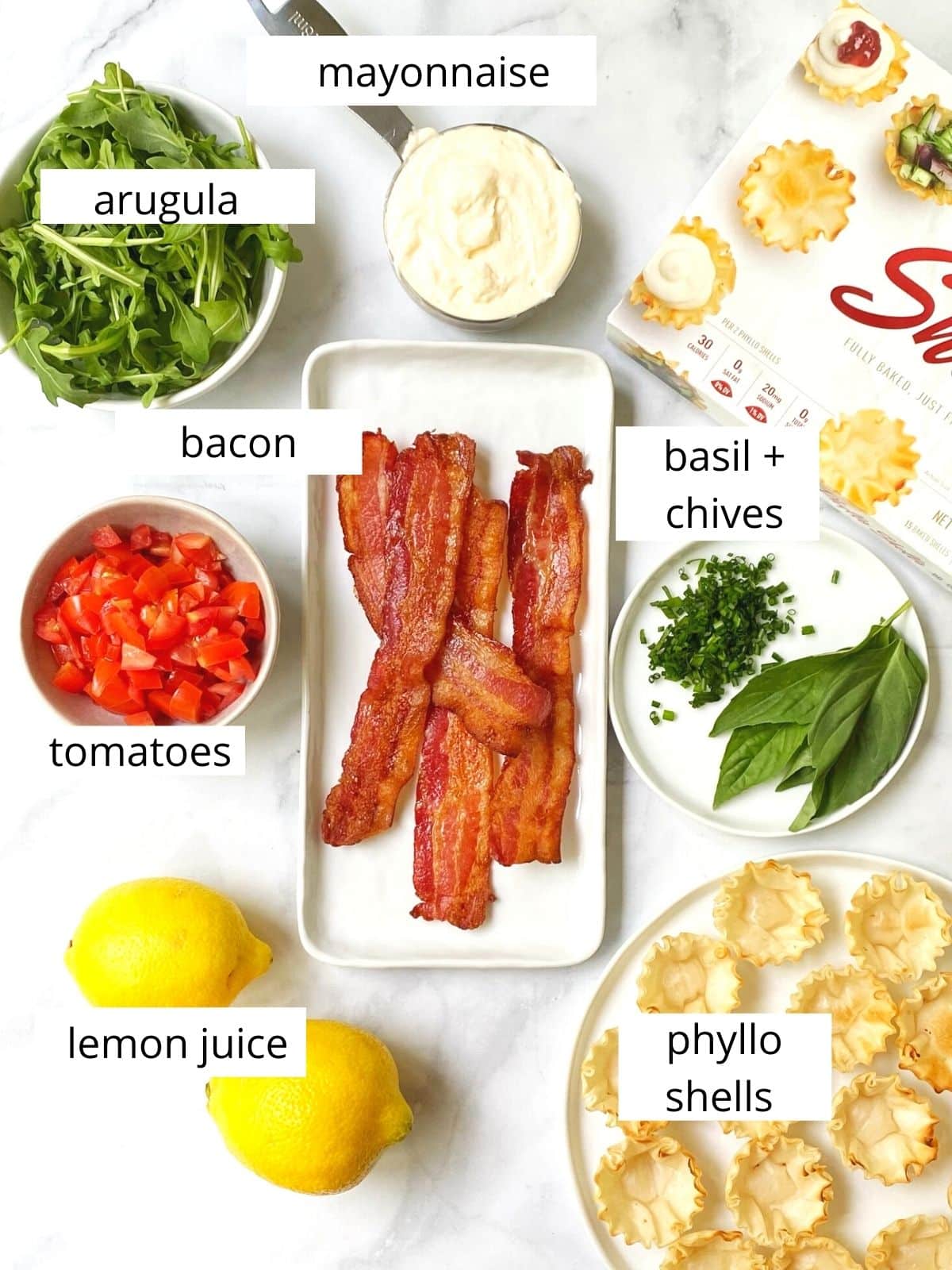 array of ingredients - arugula, mayo, herbs, bacon, tomatoes, lemon, and phyllo shells