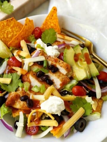 taco salad in white bowl with a fork