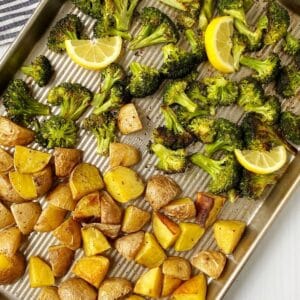 pan of roasted potatoes and broccoli garnished with lemon