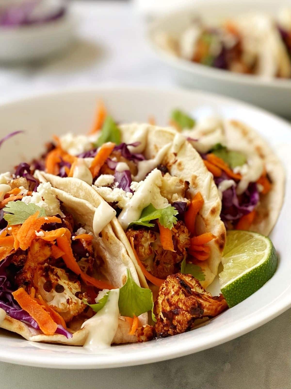 close up of tacos in a white dish