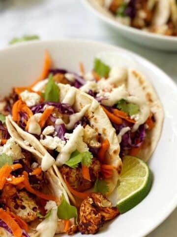 close up of tacos in a shallow white bowl.