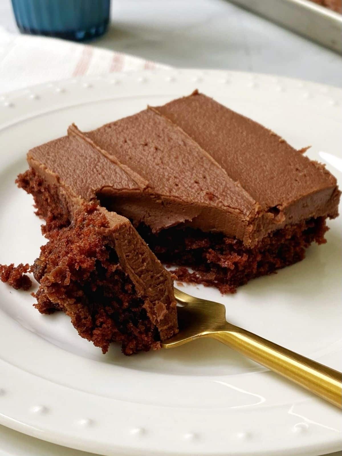 forkful of cake next to piece of cake on a plate