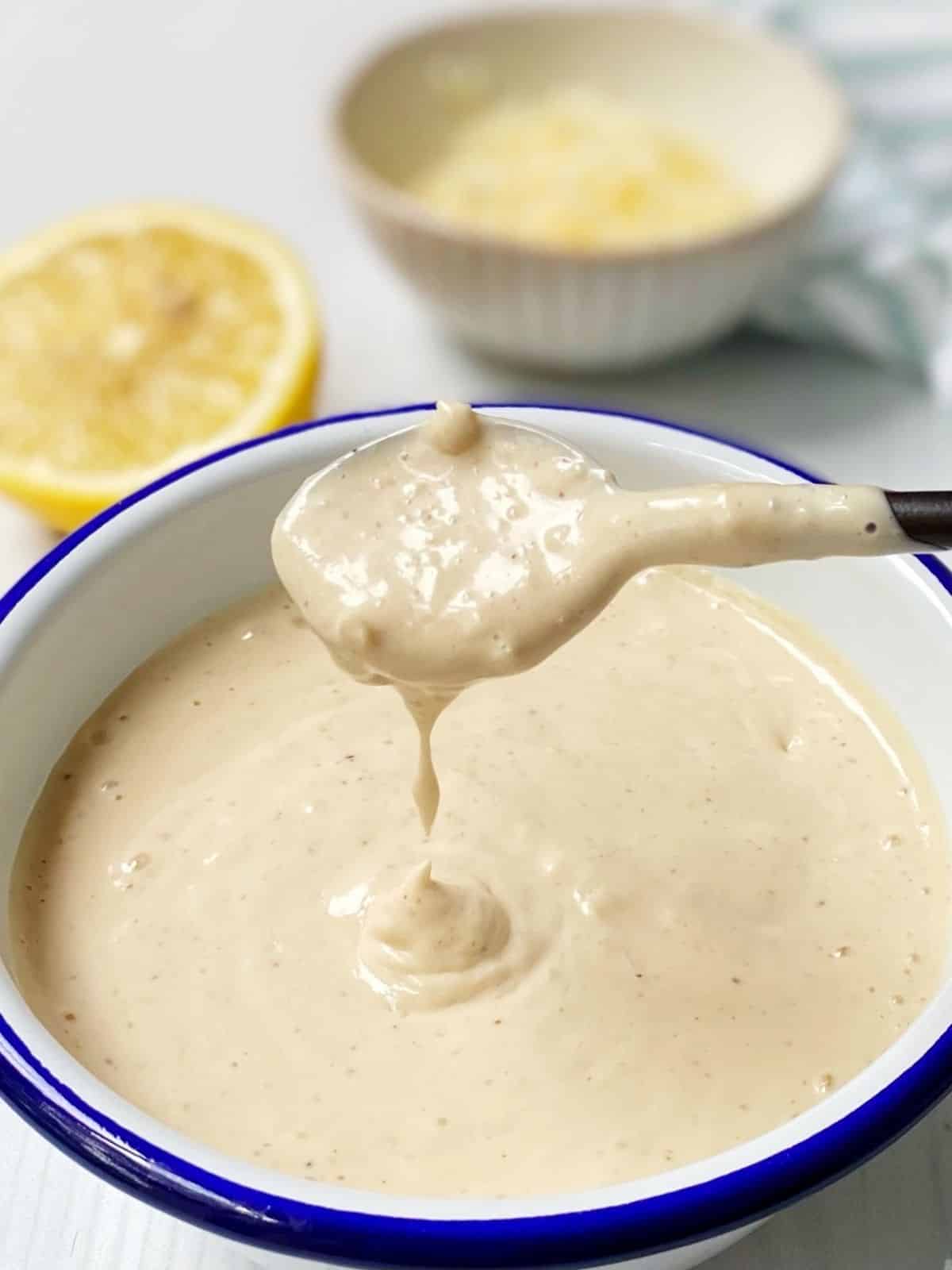 spoon in white bowl of dressing