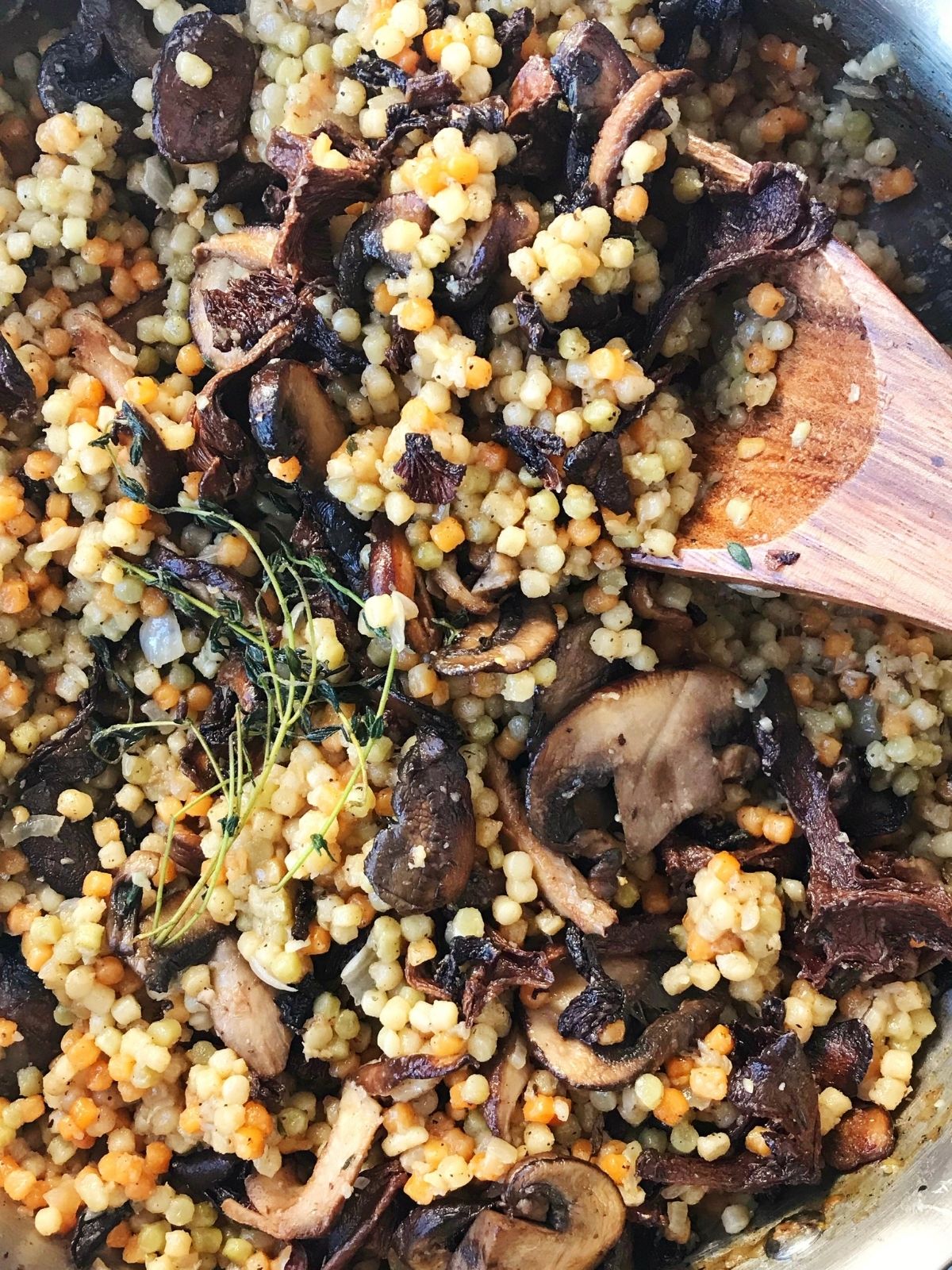 couscous and mushrooms mixed together in skillet