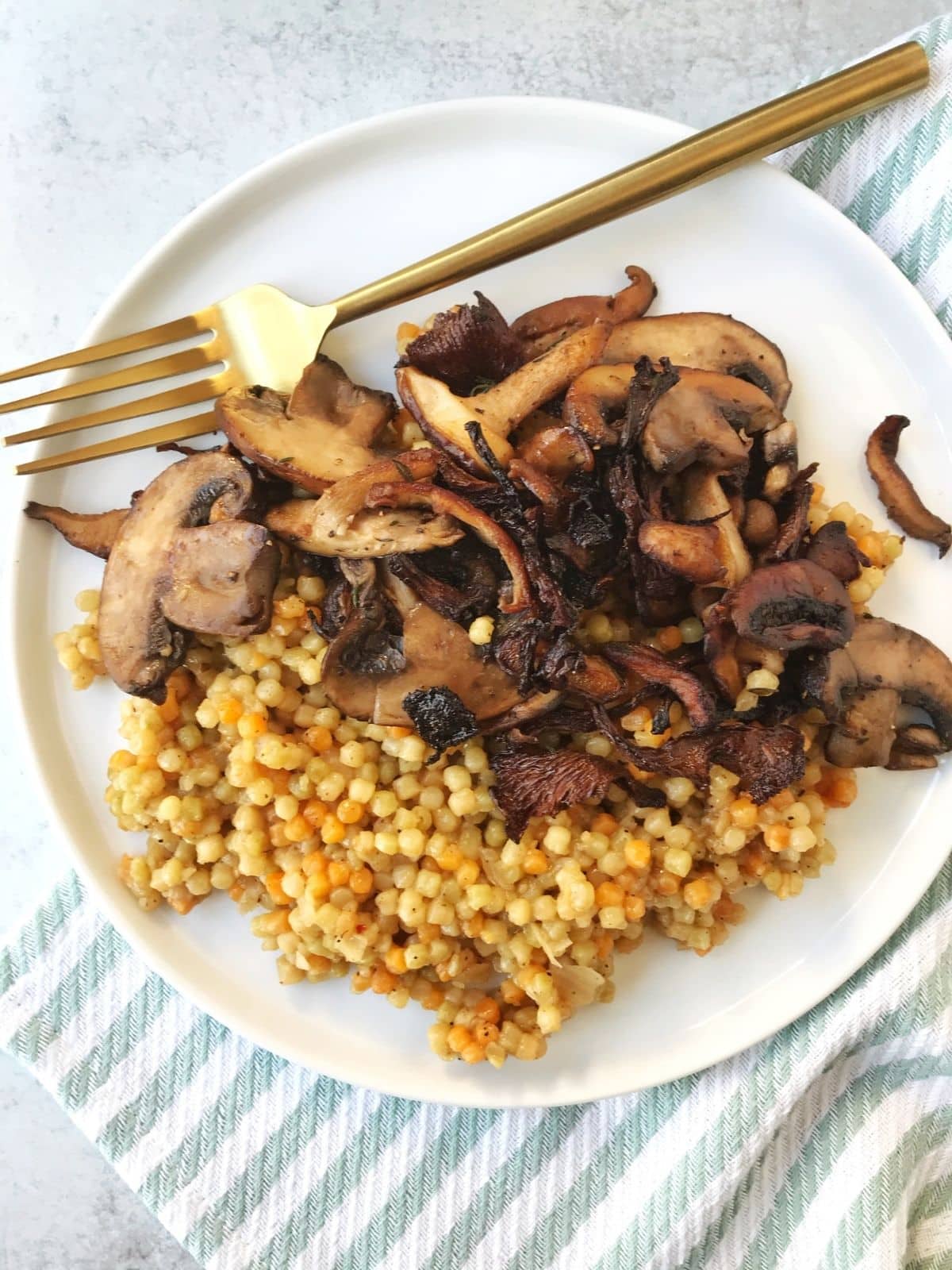 fork on a plate with couscous and mushrooms