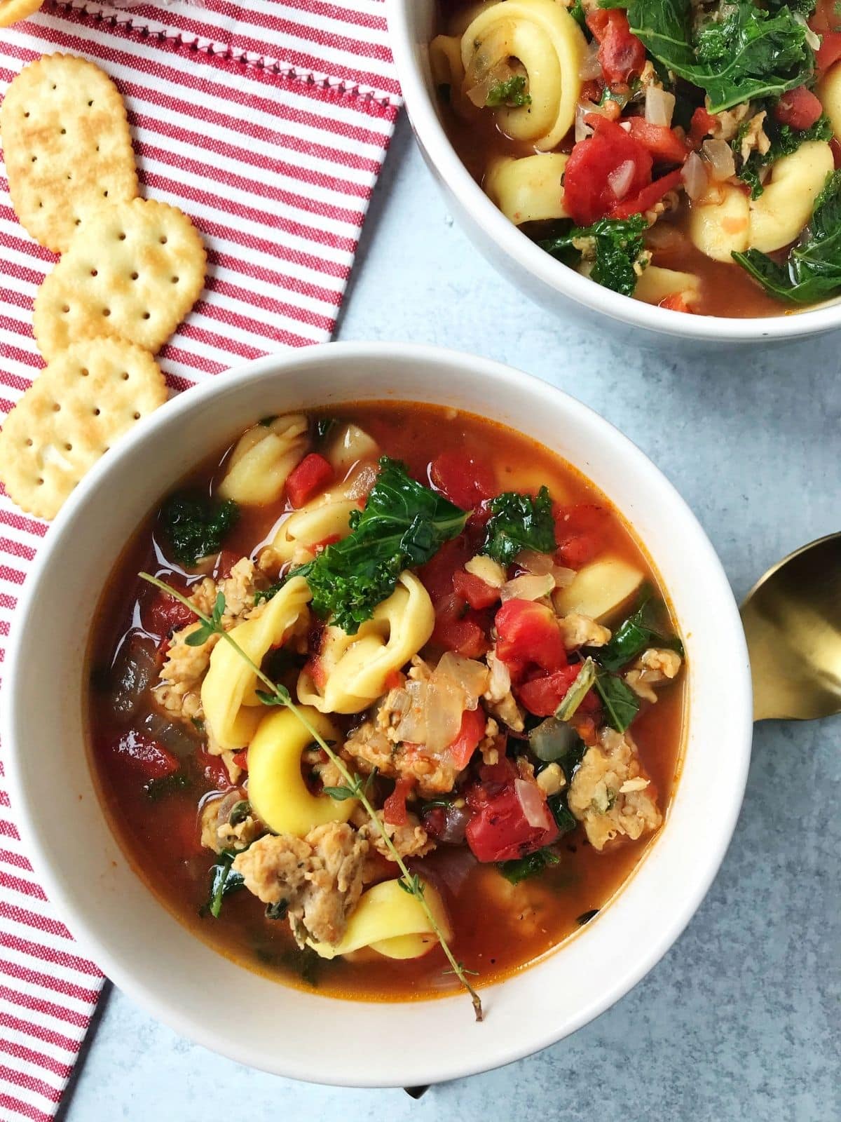 bowls of soup with crackers laying on the side