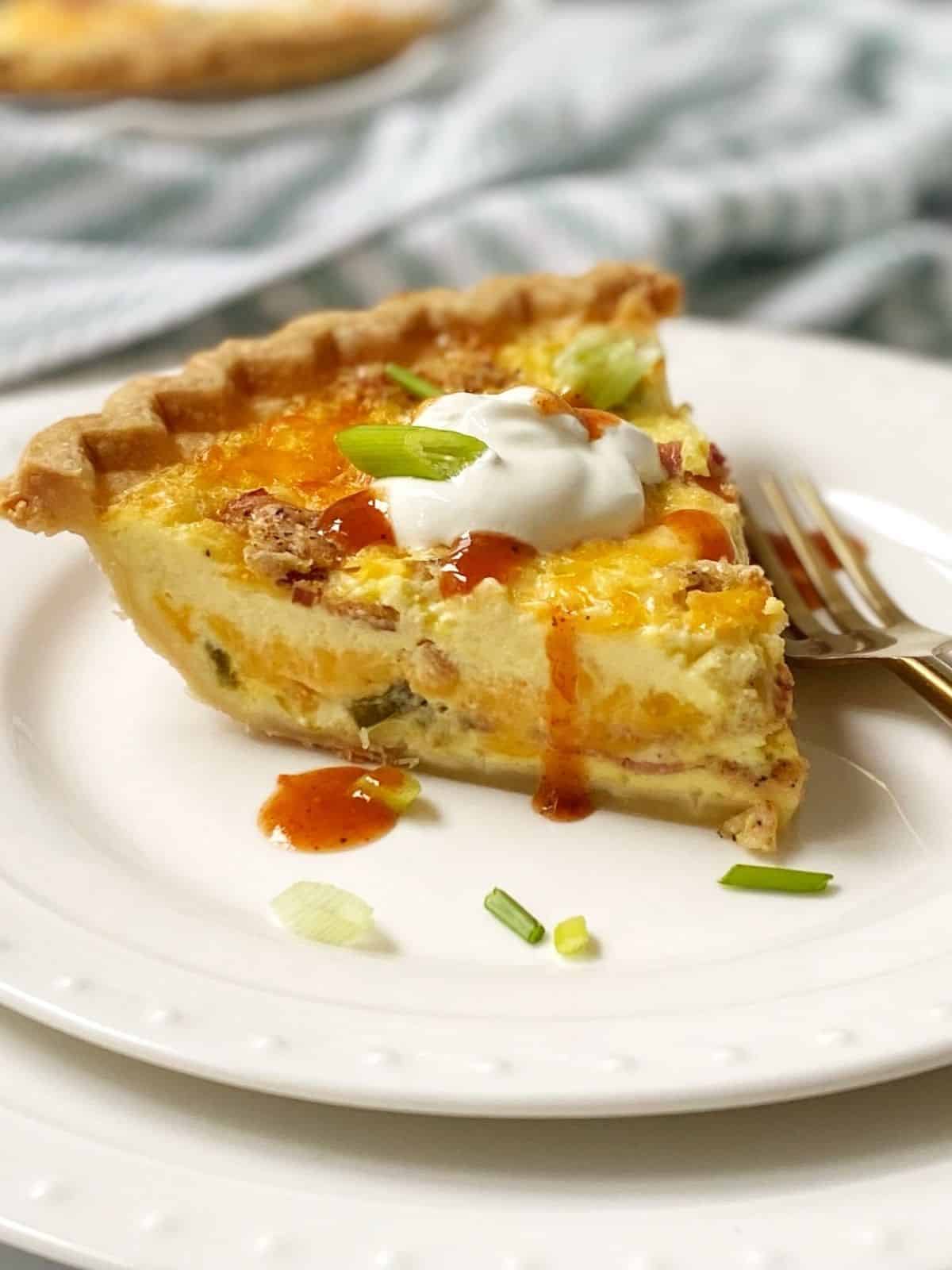 close up of slice of quiche on a plate.