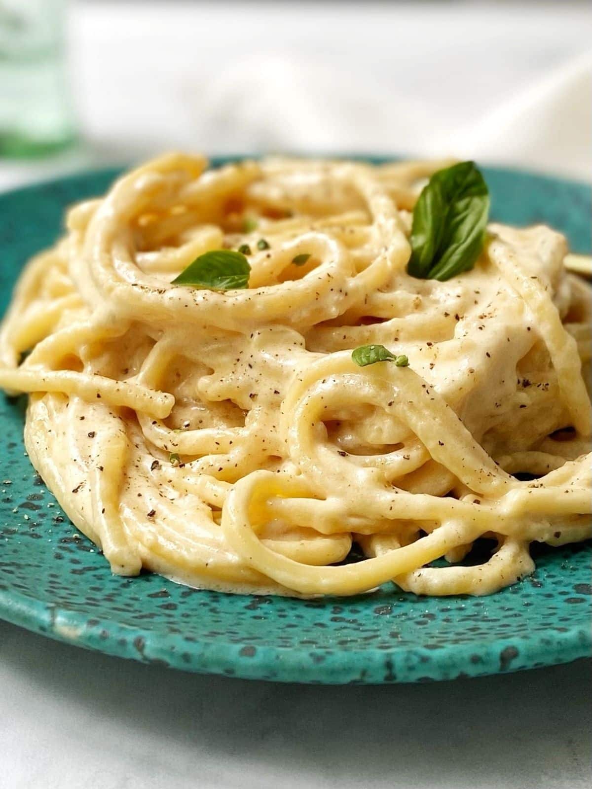 close up of alfredo sauce with pasta on a plate