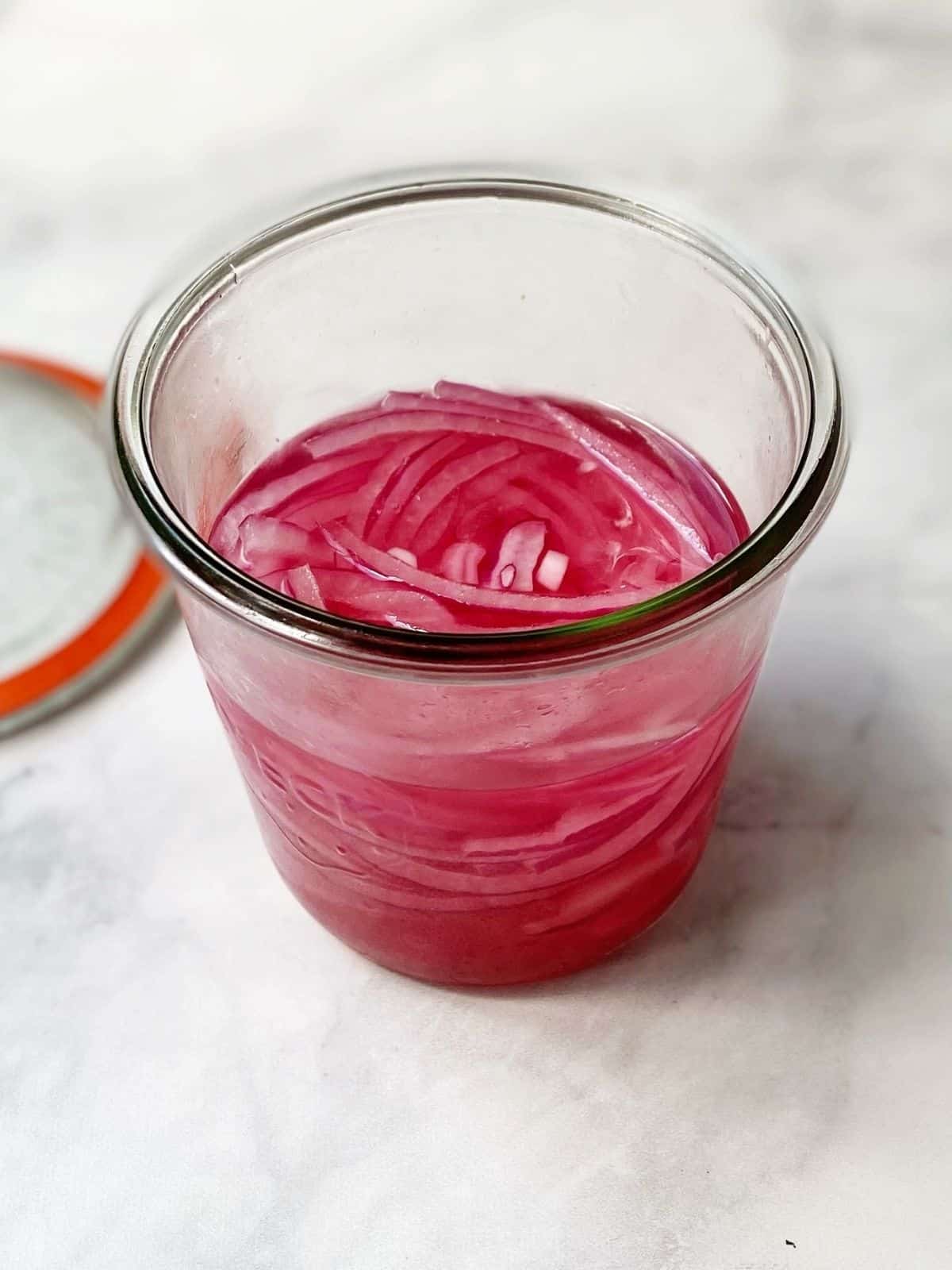 pickled red onions in a jar.