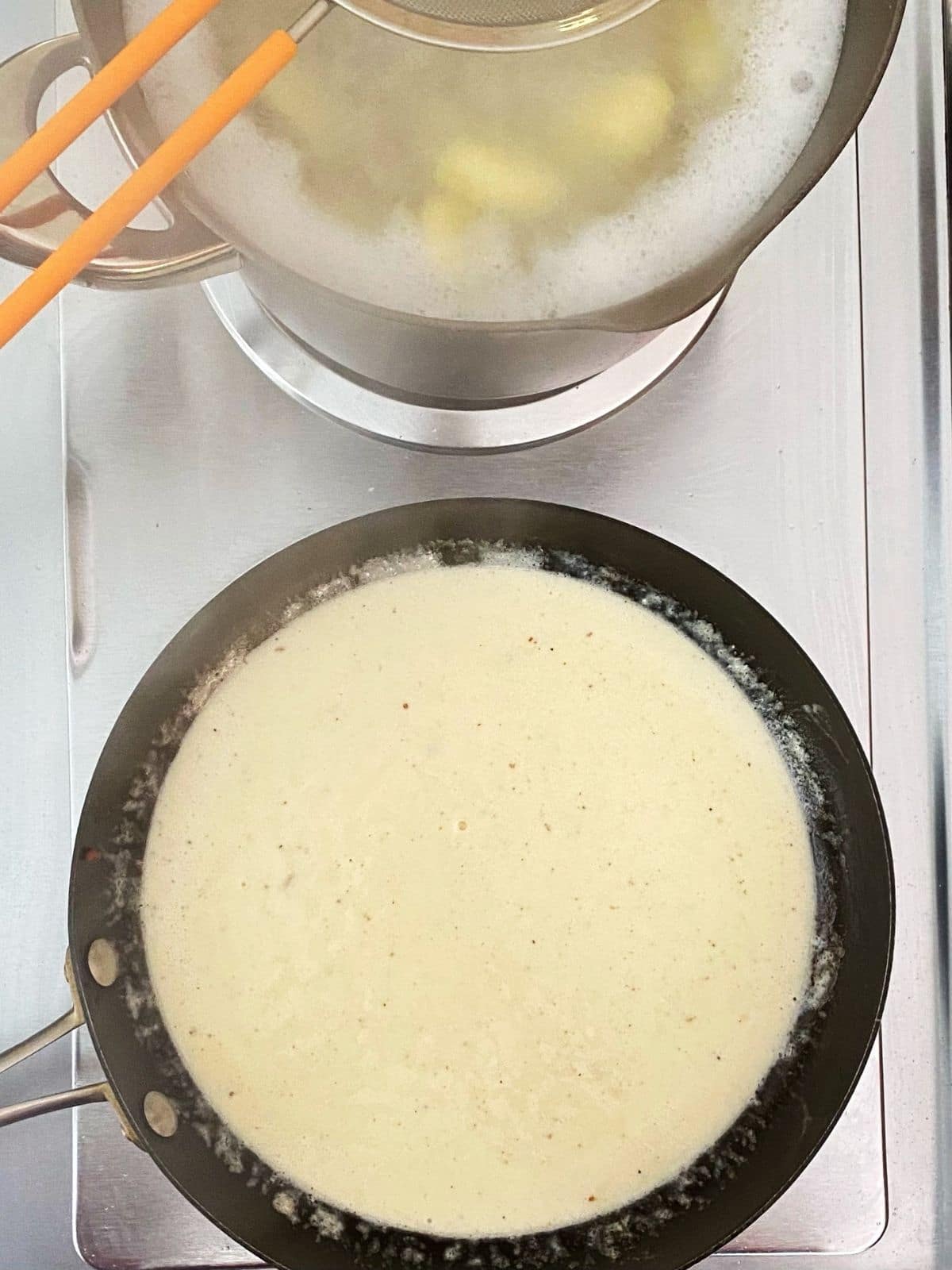 pot of Gnocchi boiling and carbonara sauce in skillet