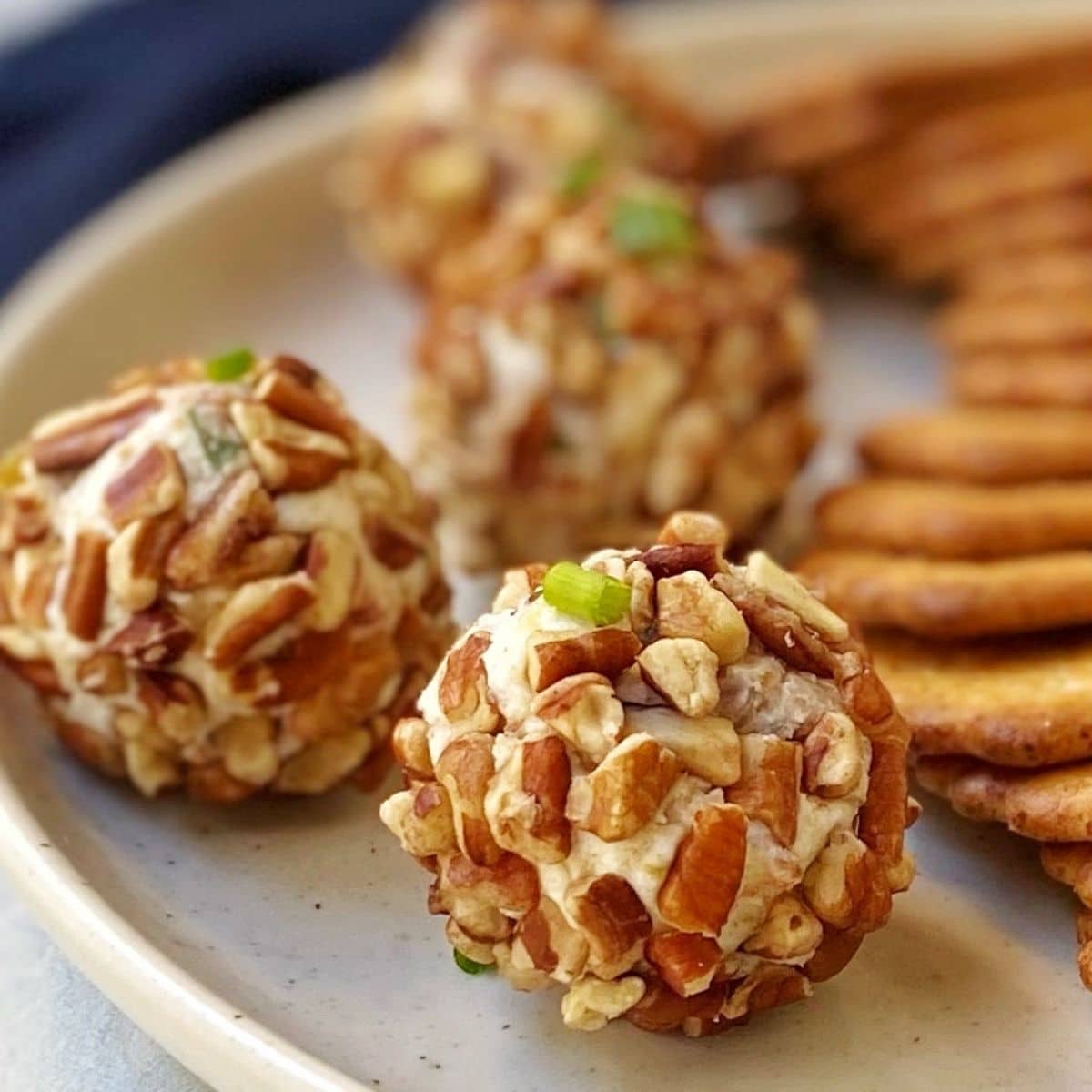 close up of cheese balls on a plate with crackers