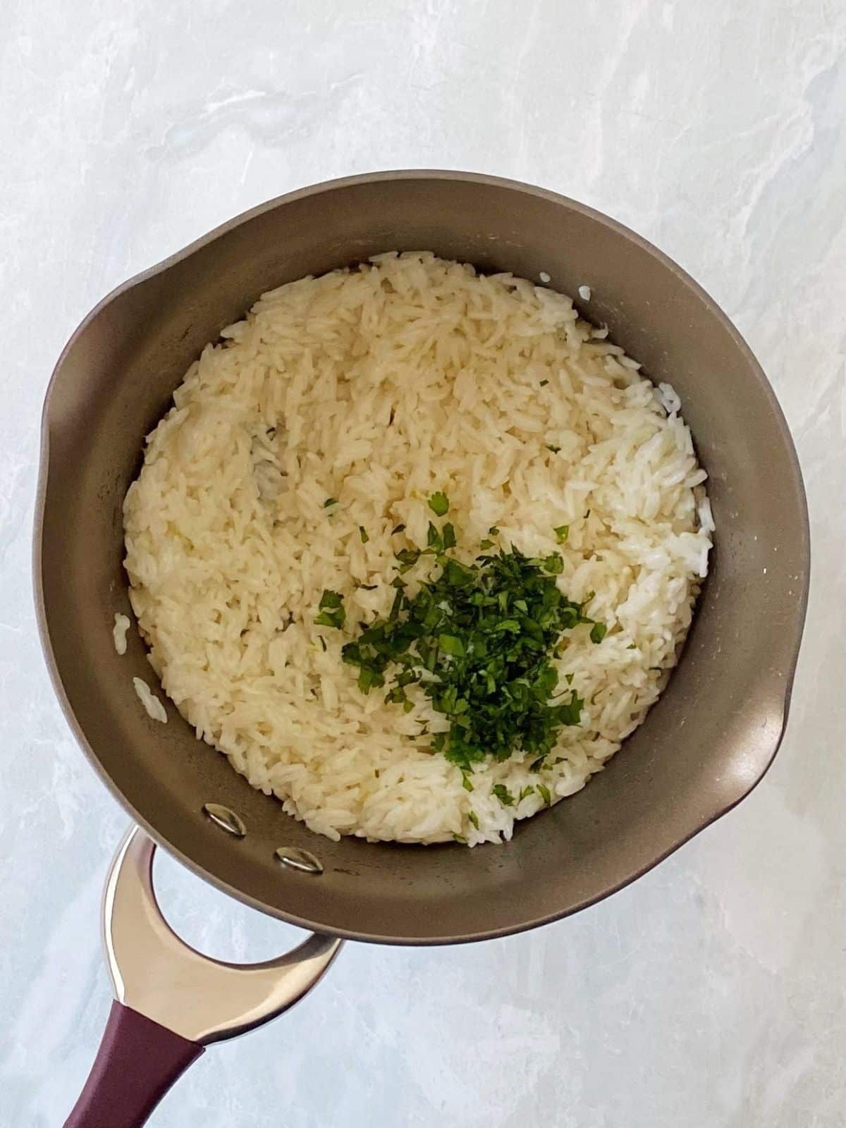 adding cilantro to cooked rice