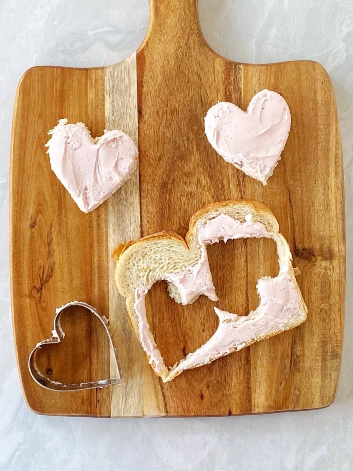 cutting heart shapes out of bread.